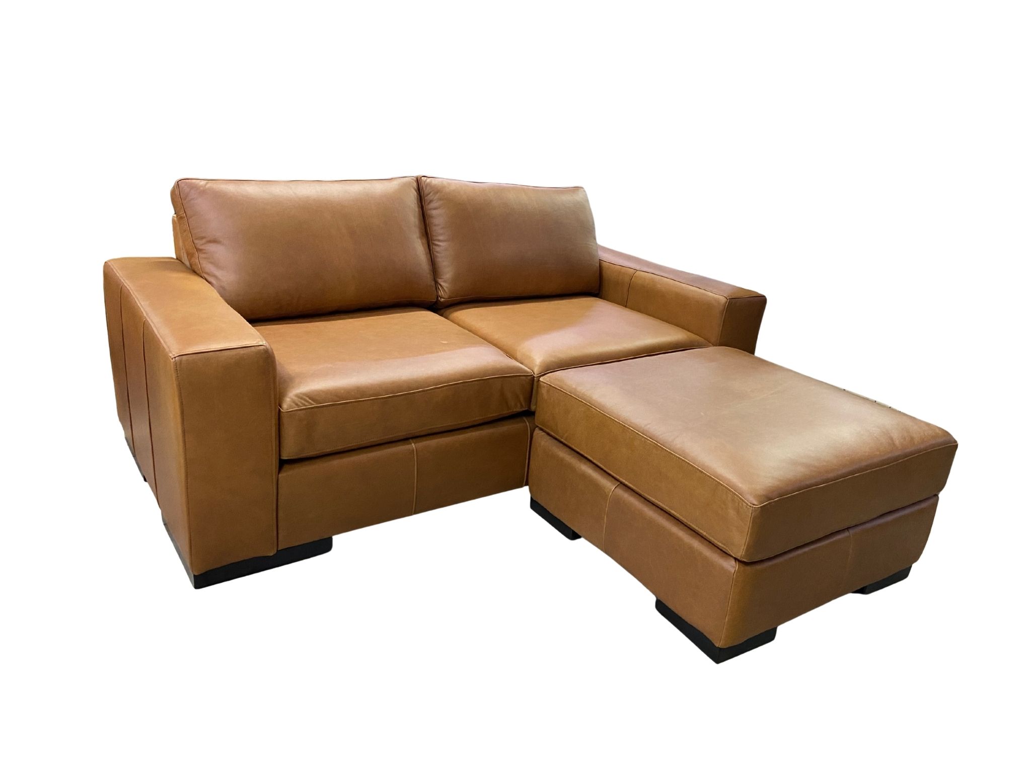 Impala tan genuine leather sofa with the optional matching ottoman positioned as a footrest